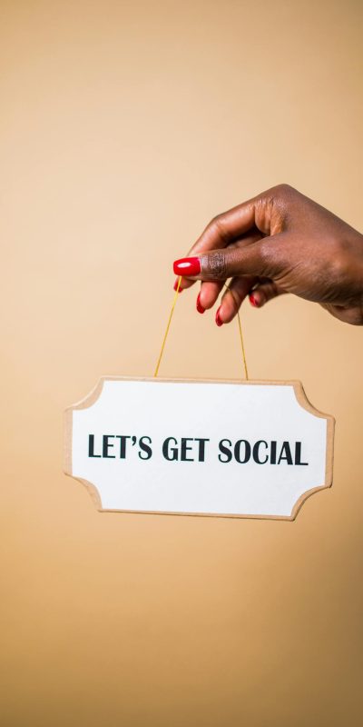 A hand holding a "Let's Get Social" sign, ideal for marketing and social media themes.